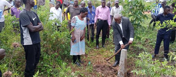 The Resident District Commissioner of Kumi plants a concrete pillar during the launch of the wetland demarcation in Kamaca under GCF project.